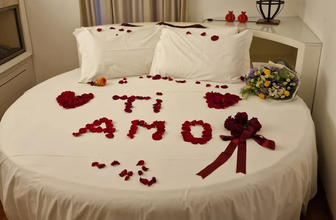 Allestimento romantico con petali e fiori sul letto della Suite